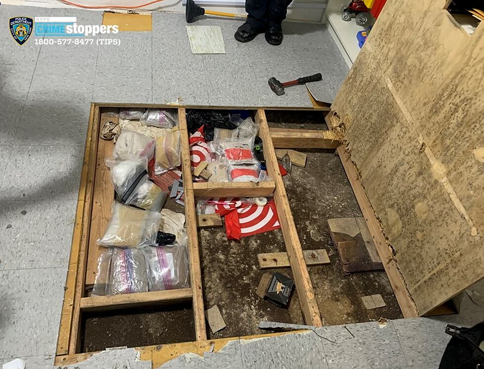 In this photo provided by the New York City Police Department, a trap door leans open over...