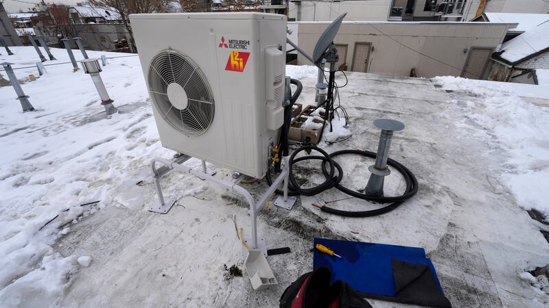 FILE - A condenser sits on the roof during the installation of a heat pump on Jan. 20, 2023,...