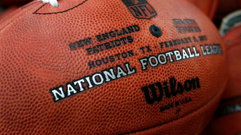 The first NFL Super Bowl LI football sits in a bin with other balls to be stamped with the New...